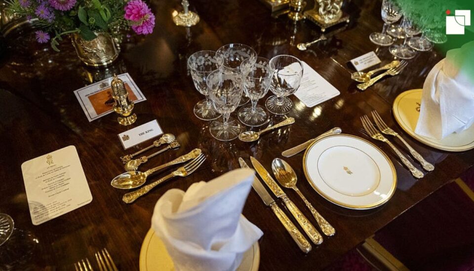 Close-up of a formal dining table set with elegant crystal glassware, polished silver cutlery, and white napkins, showcasing refined table etiquette.